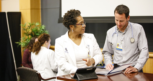 Two nurses consulting one another