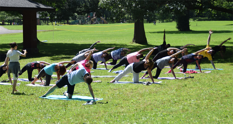 Coworkers doing yoga outside